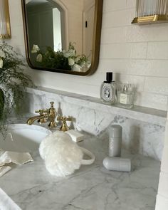 a bathroom with marble counter top and gold faucet, soap dispenser