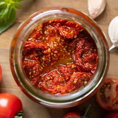 tomatoes and garlic in a jar on a table