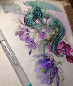 a drawing of a dragon and flowers on a sheet of paper next to a marker