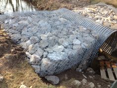 a pile of rocks sitting next to a river