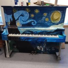 an artistic piano is painted to look like the starry night, and it's sitting in front of a window