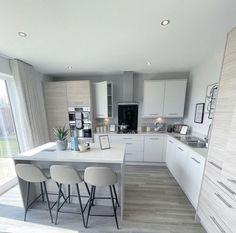 a large kitchen with white cabinets and counter tops