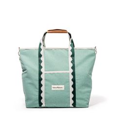 a green and white tote bag with scallop trims on the front