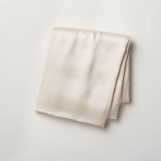 two folded napkins sitting on top of each other in front of a white wall