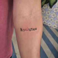 a person with a tattoo on their arm that says revolution above the word revolution in cursive font