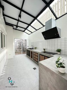 an open kitchen with white tile flooring and black metal roof over the sink area