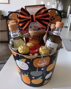 a halloween gift basket with booze, liquor and candies in it on a table