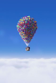 a hot air balloon floating in the sky with clouds around it and blue skies above