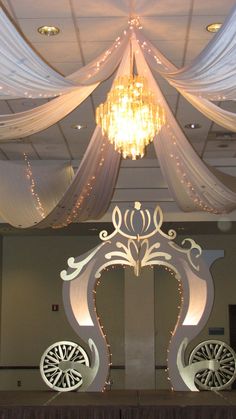 the ceiling is decorated with white drapes and lights