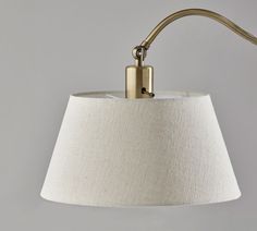 a lamp that is on top of a white table cloth with a light attached to it