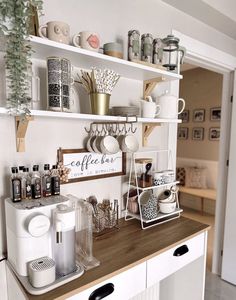 a kitchen counter topped with lots of cups and saucers on top of wooden shelves