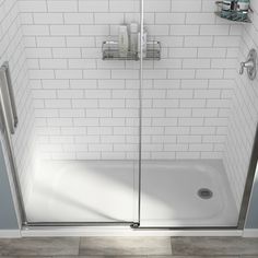 a white tiled bathroom with a walk in shower