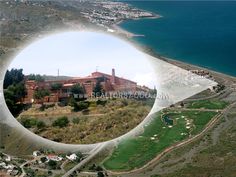 an aerial view of a golf course with the ocean in the back ground and houses on the other side