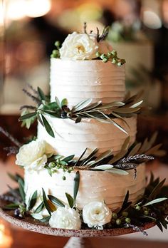 a wedding cake with white flowers and greenery on top is featured in the instagram