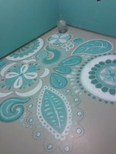 the floor is painted with blue and white paisley designs, which are on top of a light green wall