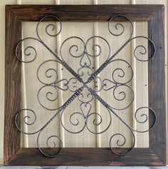 an old window frame with wrought iron work on the outside and wood trim around it