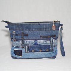 a purse made out of old jeans with buttons and zippers on the front pocket