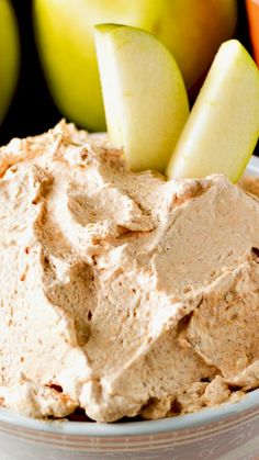 a close up of a bowl of food with apples in the background