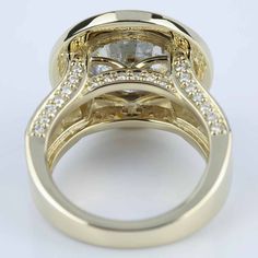 a close up view of a gold ring with diamonds on the sides and an oval shaped diamond