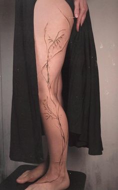 a woman's legs with vines and leaves on the bottom part of her leg