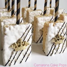 cake pops with white frosting and black stripes are arranged in rows on a table