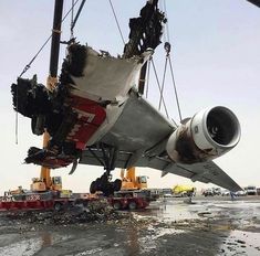 an airplane is being lifted from the ground by cranees and other equipment in front of it