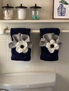 two towels hanging on the wall above a toilet