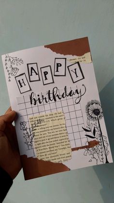 a person holding up a piece of paper with the words happy birthday written on it