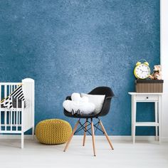 a baby's room with blue walls and white furniture