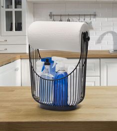 a kitchen counter with a basket holding toilet paper and cleaning products on top of it