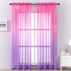 pink and purple sheer curtains hanging in front of a window with white dresser next to it