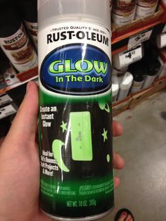 a person holding a can of glow in the dark spray on their left hand and it's green