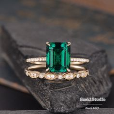 an emerald colored stone surrounded by white diamonds