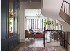 a living room filled with furniture and a spiral stair case in front of a window