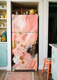 a pink and gold refrigerator in a kitchen