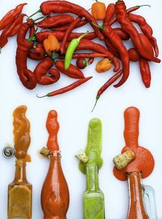 hot peppers and other condiments are arranged on a white surface