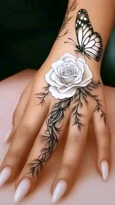 a woman's hand with tattoos on it and a white rose in the middle