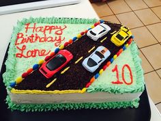 a birthday cake with cars on the road