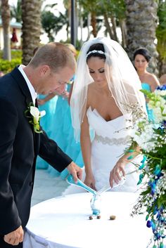 a bride and groom cutting their wedding cake