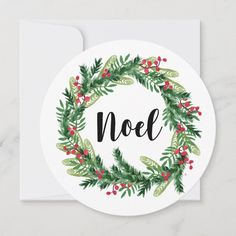 a christmas wreath with the word noel written in black ink on a white envelope card