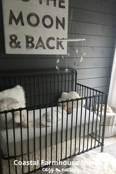 a baby's room with a black crib and white bedding