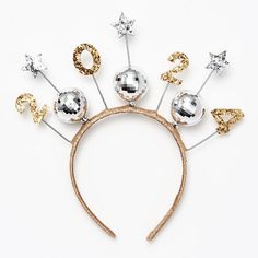 a headband with silver and gold glitter numbers on it, along with two star shaped hair pins