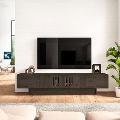 a large flat screen tv sitting on top of a wooden entertainment center in a living room