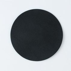 a round black object sitting on top of a white surface