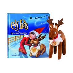 the elf pets book is next to a stuffed reindeer with its head on it's back