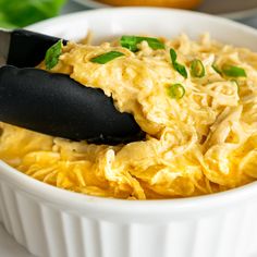 a white bowl filled with food and a black spatula sticking out of the top