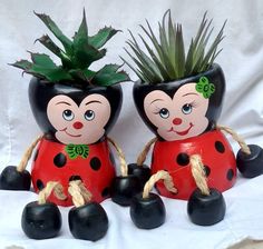 two black and red pots with plants in them