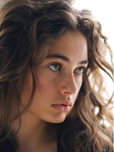 a close up of a person with long hair and blue eyes looking at the camera