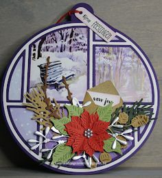 a christmas ornament hanging on the side of a wooden wall with snow and trees