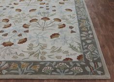 a rug with flowers and leaves is on the floor in front of a wooden floor